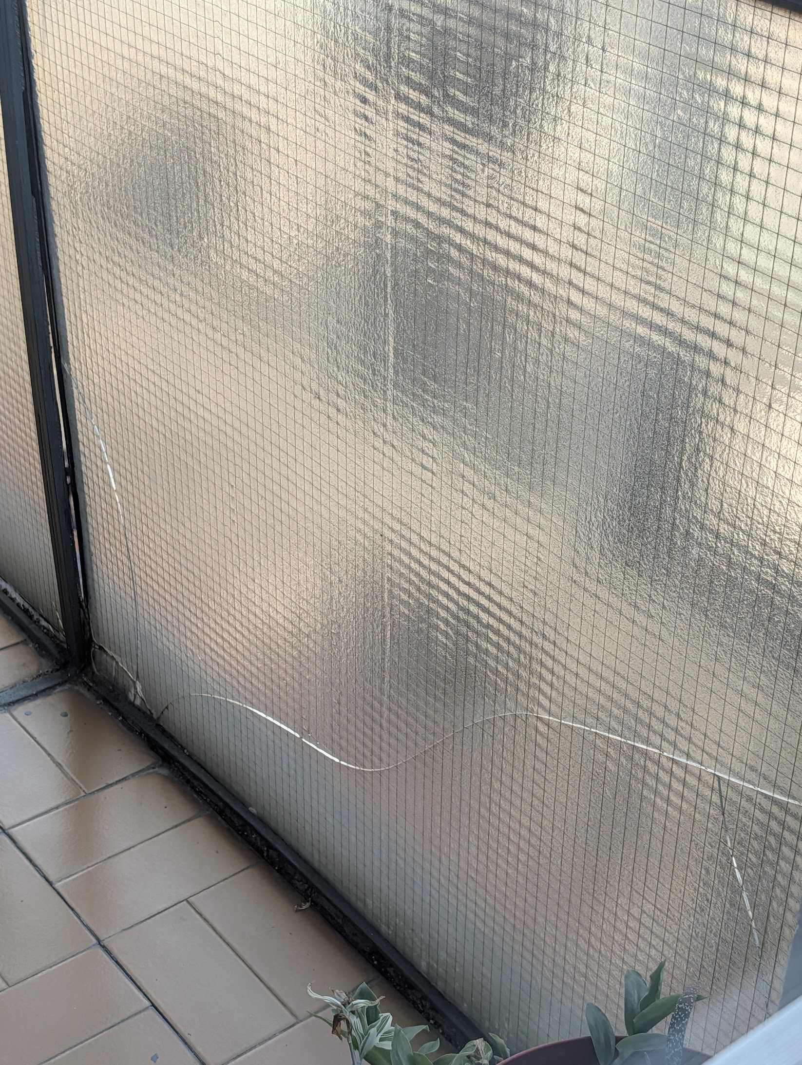 Cracked pane of glass on the apartment balcony