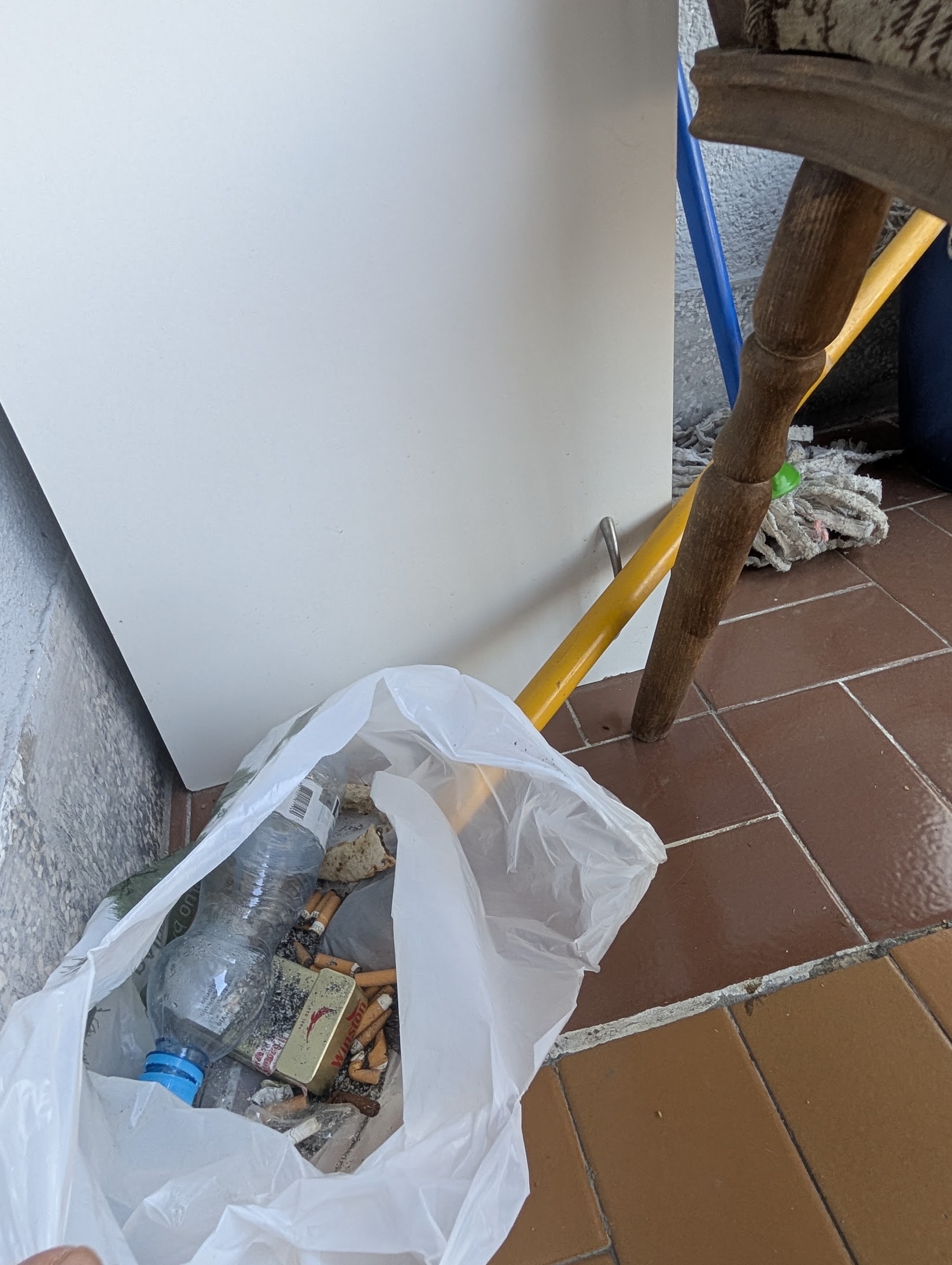 Bag of rubbish and cigarette ends left on the balcony at check-in