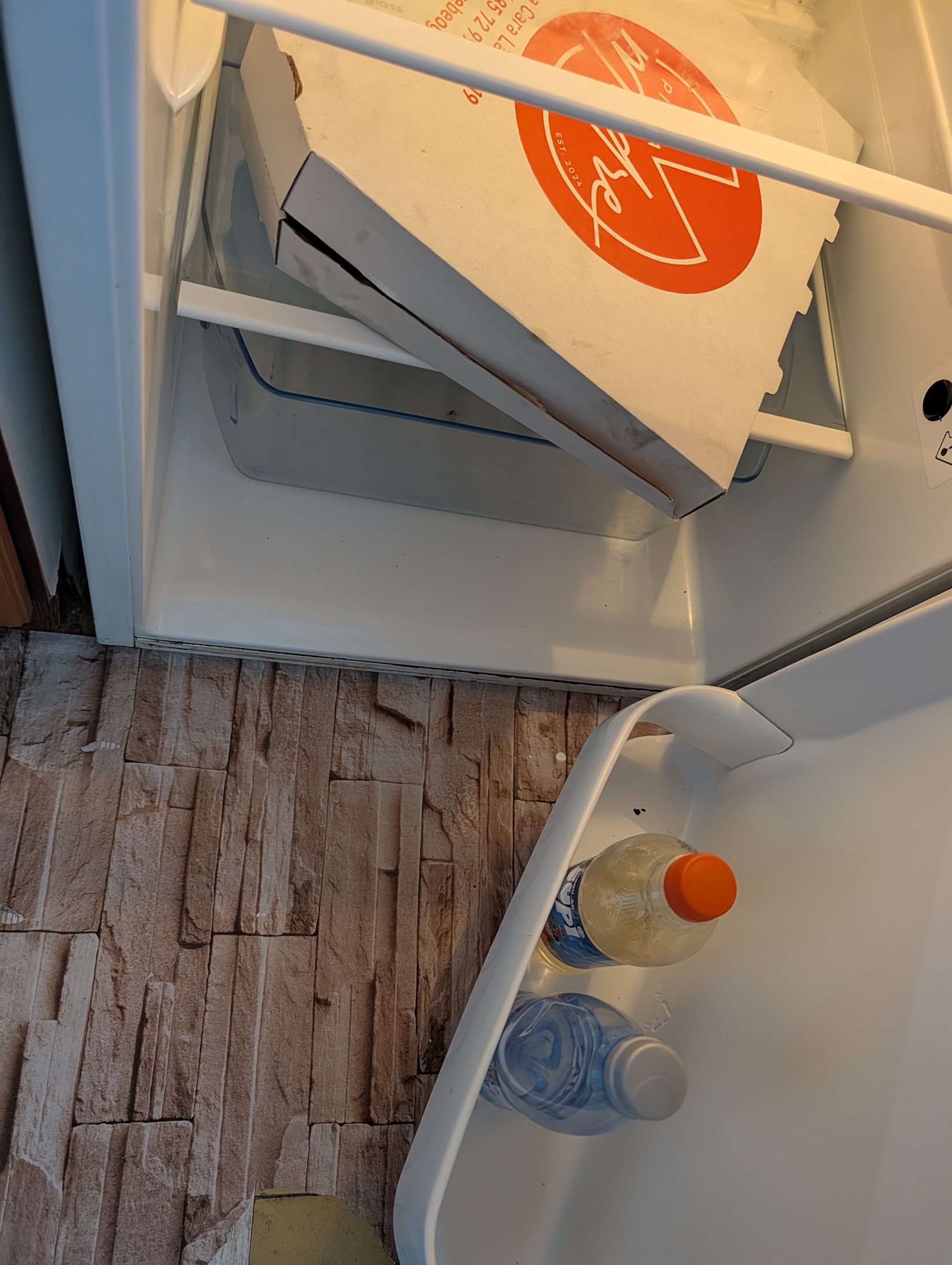 Old pizza box and old drinks left in the refrigerator at check-in